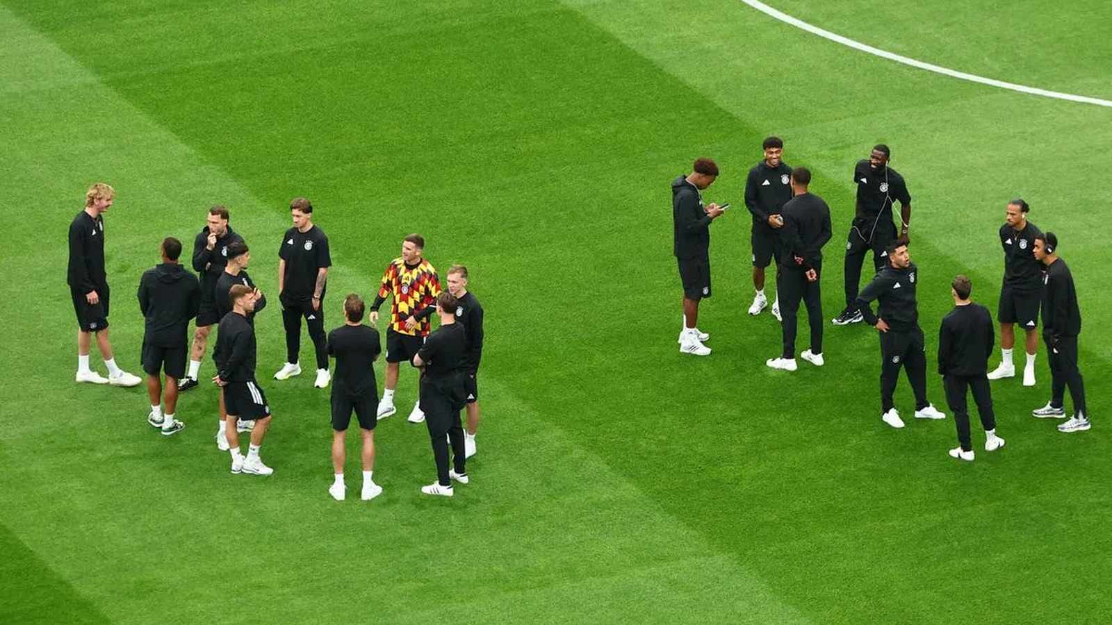 Aleksandar Pavlovic and German national team players standing on the pitch during training