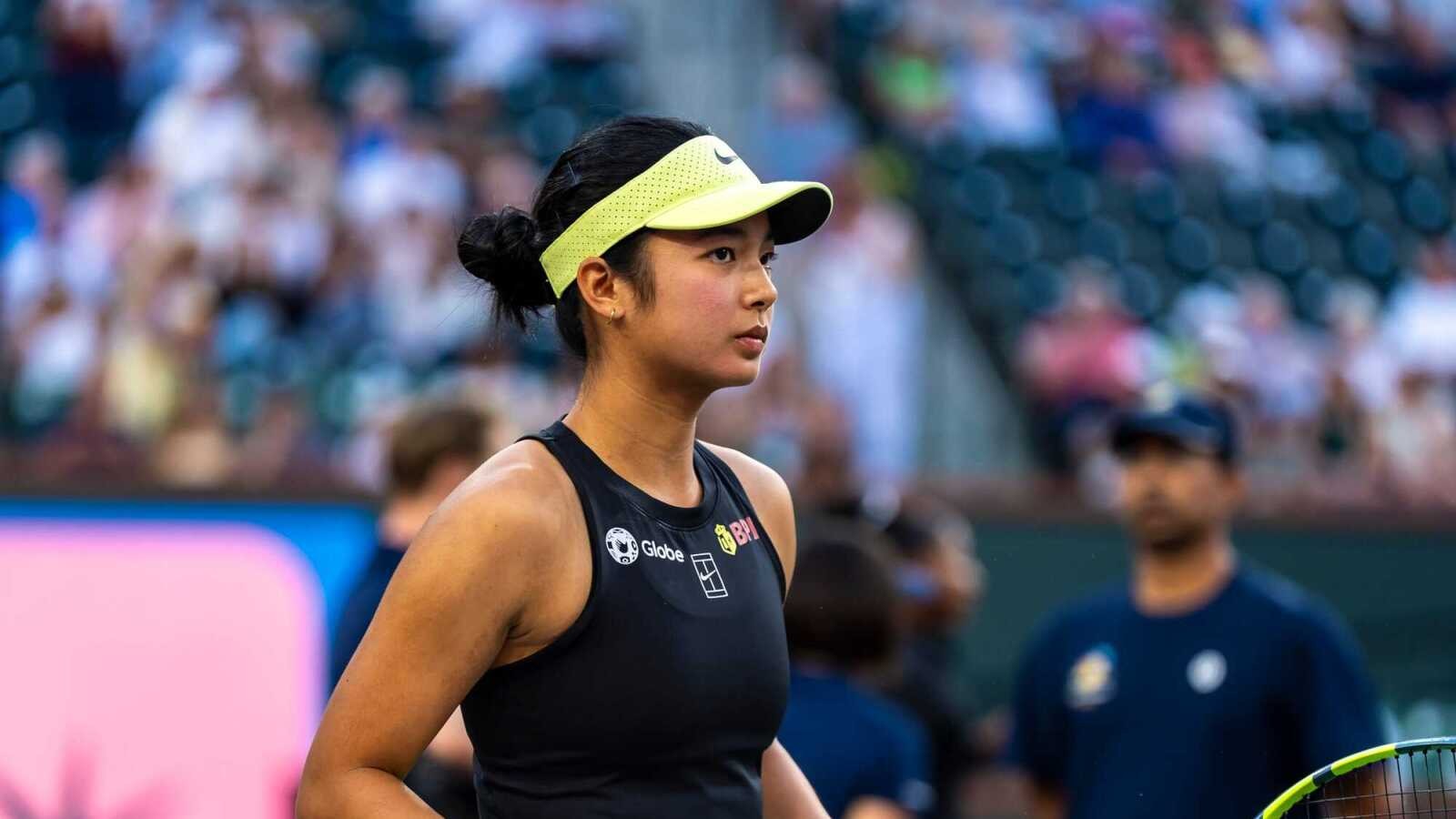 Professional tennis player Alexandra Eala wearing a black tank top and yellow visor