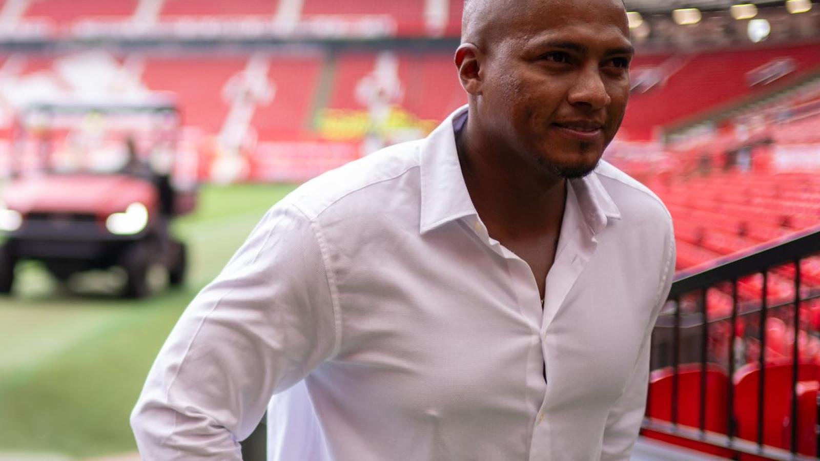 Former Manchester United captain Antonio Valencia smiling while walking inside Old Trafford stadium