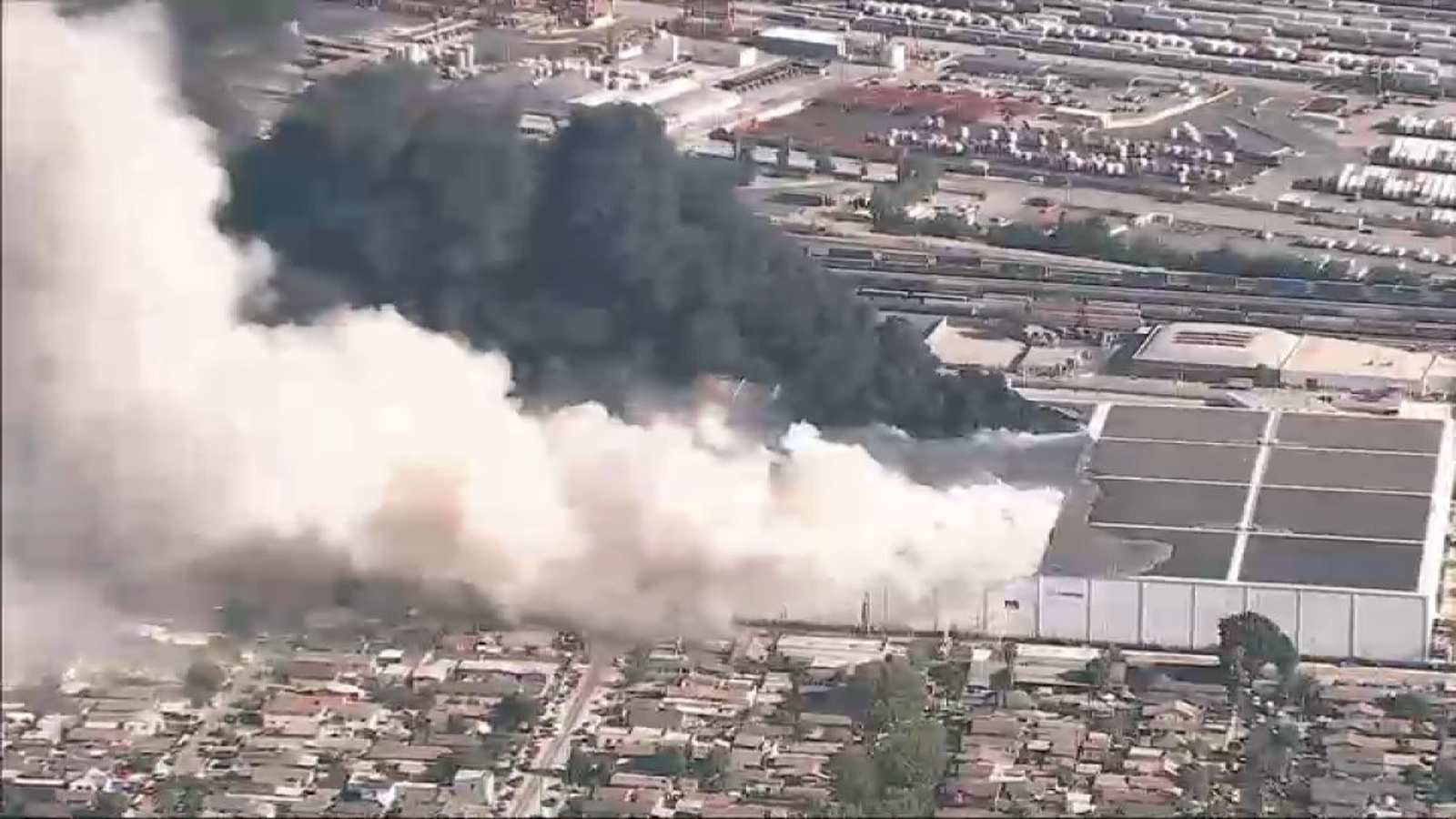 Aerial view of a large warehouse fire emitting thick smoke over Boyle Heights