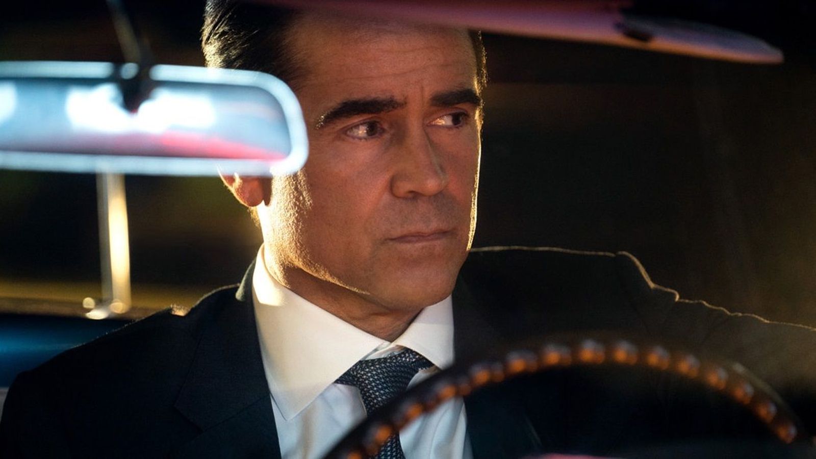 Colin Farrell driving a car while portraying detective John Sugar in a suit