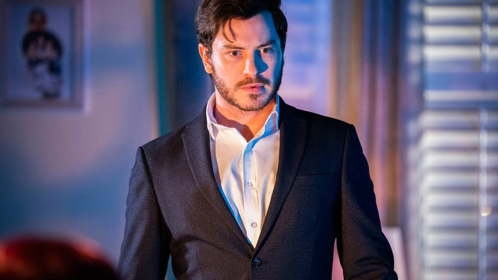 Toby-Alexander Smith as Gray Atkins wearing a suit in a dramatic scene
