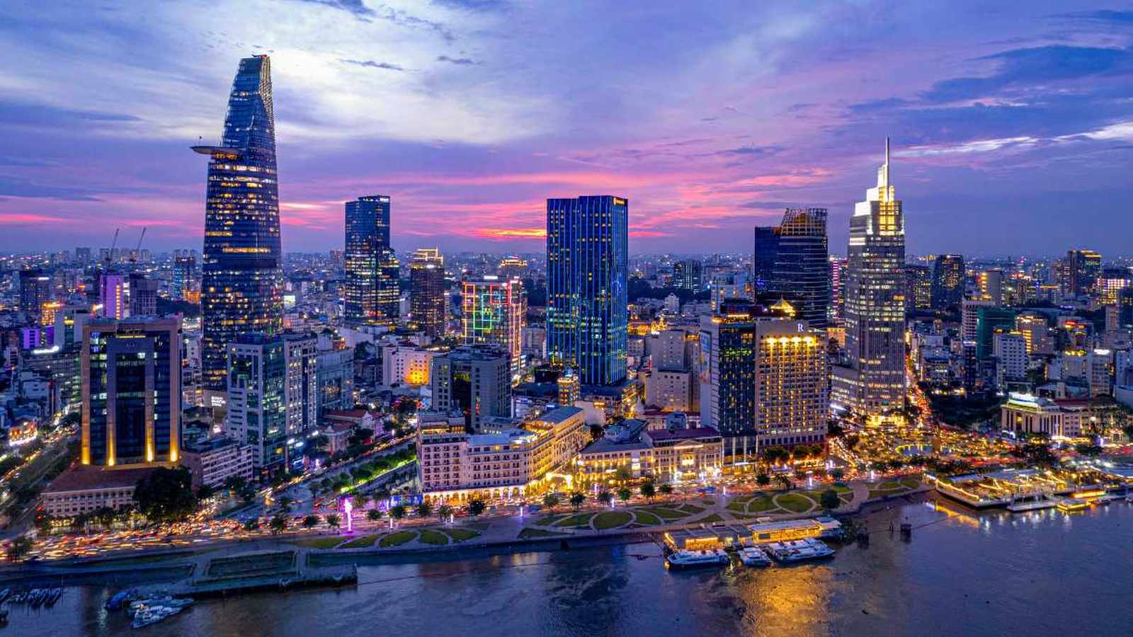 Aerial view of the illuminated Ho Chi Minh City skyline at sunset with river