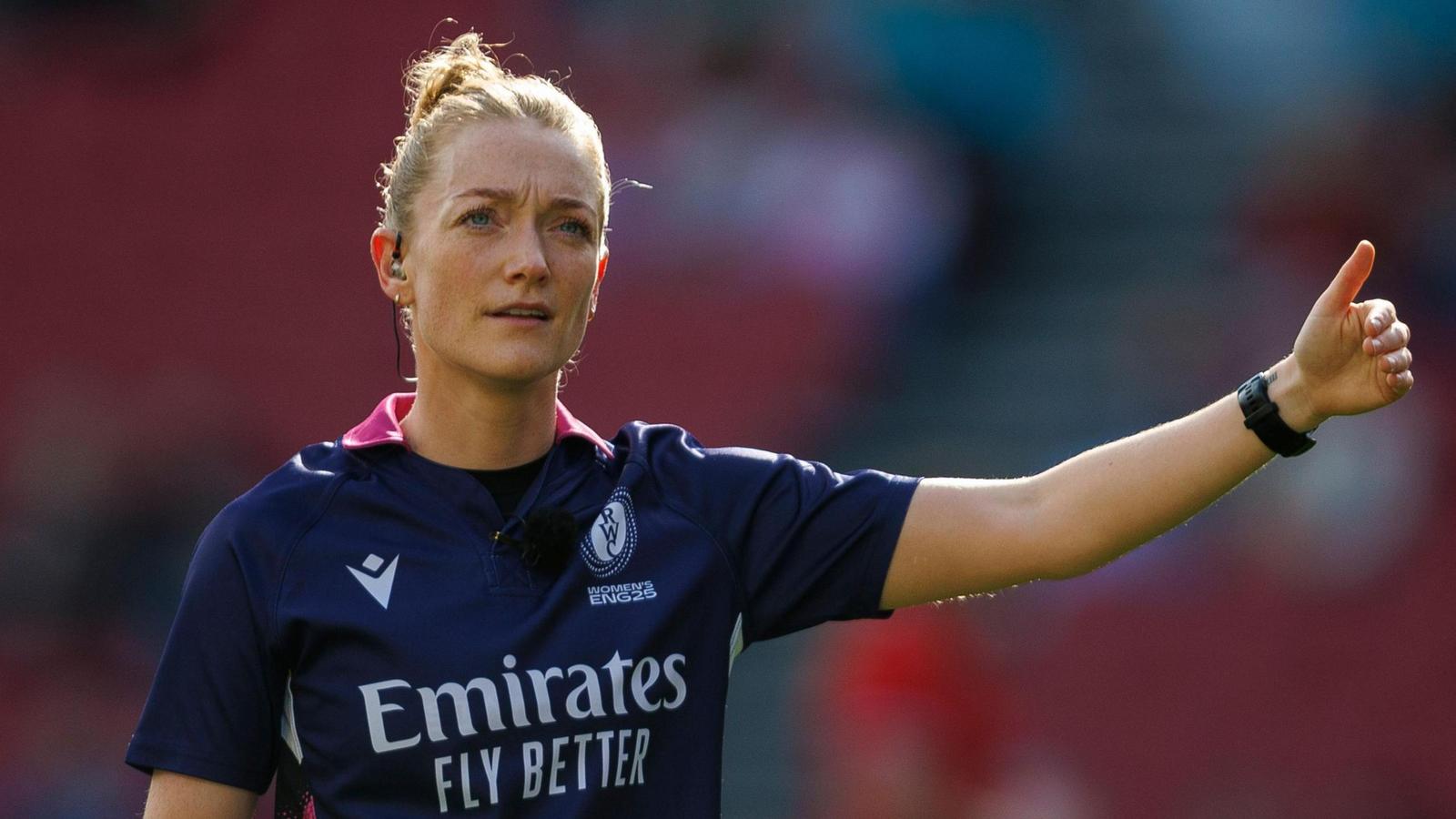 Scottish rugby referee Hollie Davidson signaling during a professional match in her kit
