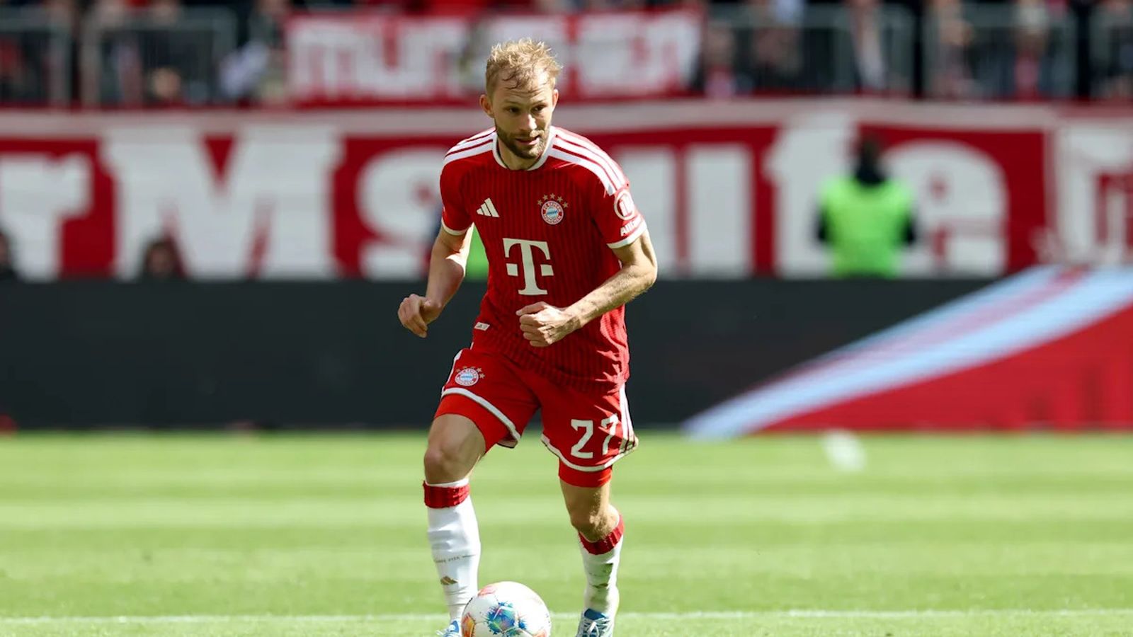 Konrad Laimer dribbling a soccer ball on the pitch in a Bayern Munich kit