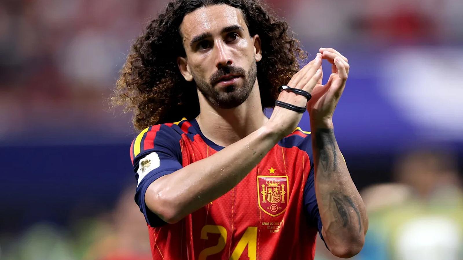 Marc Cucurella with curly hair wearing the red Spain national team football jersey