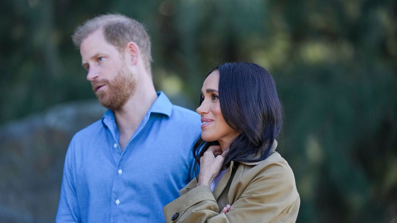 Meghan, Duchess of Sussex, and Prince Harry standing together in a candid outdoor setting