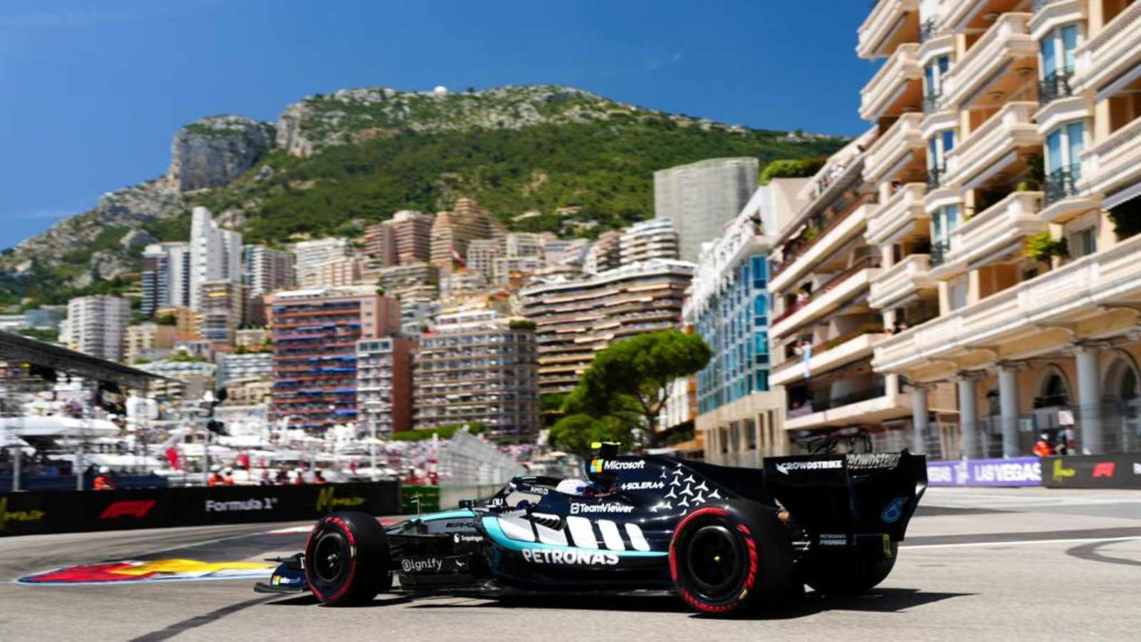 A Mercedes Formula One race car driving on the Monaco street circuit track