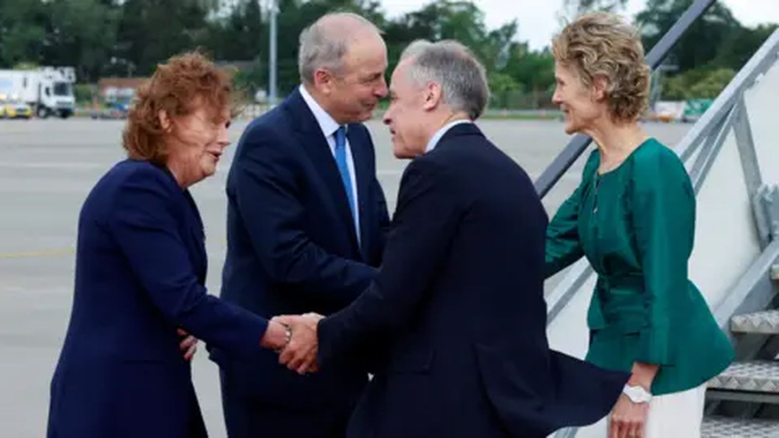 Taoiseach Micheál Martin shaking hands with a visiting official on an airport tarmac