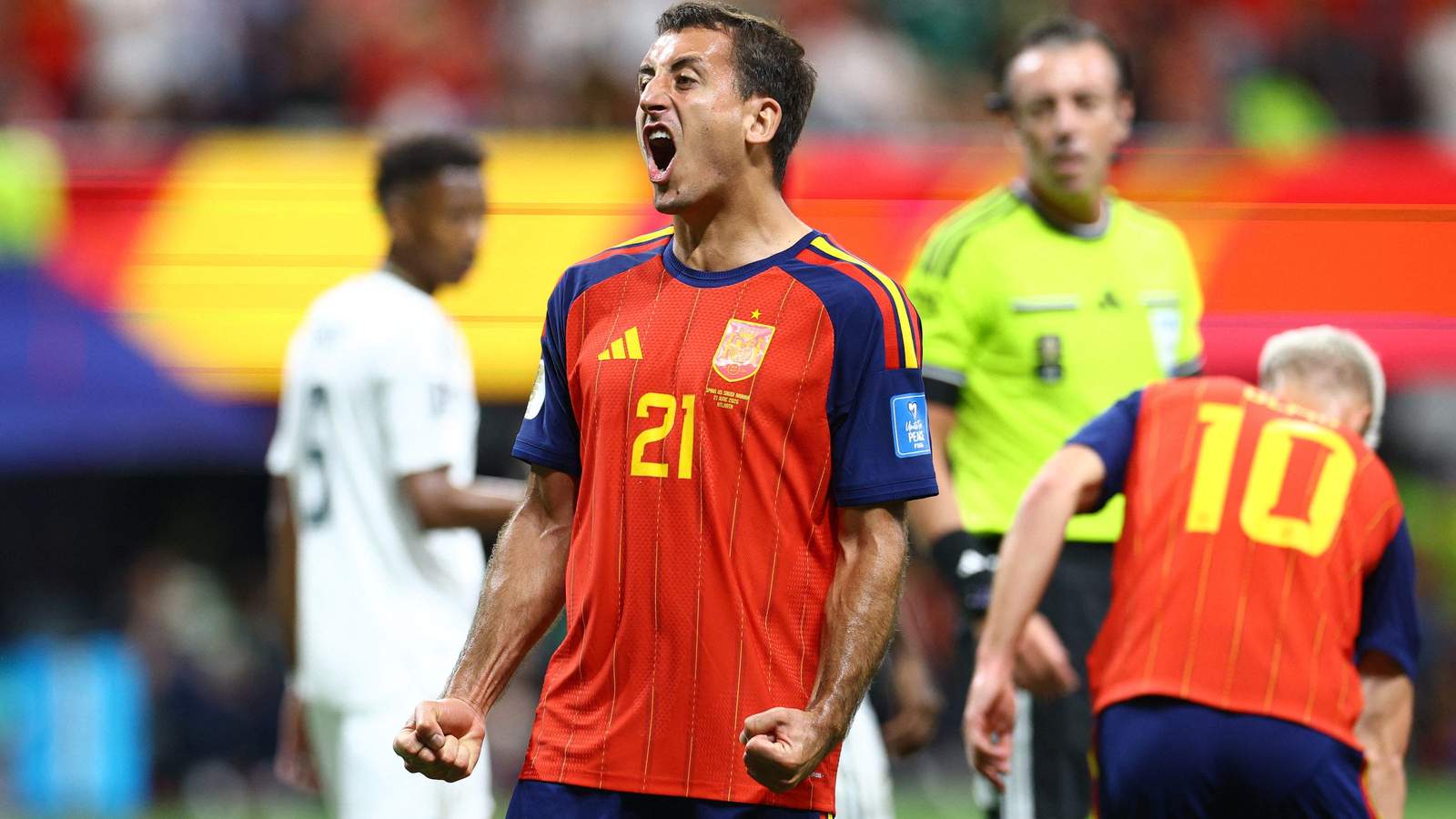 Mikel Oyarzabal in a red Spain jersey celebrating with a clenched fist shout
