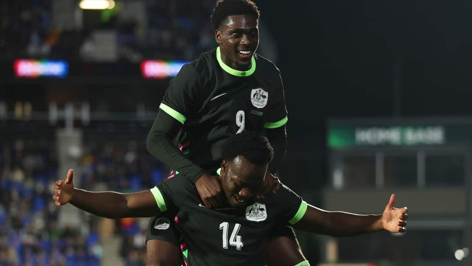 Nestory Irankunda celebrating a goal while being carried by a teammate in Australia kit