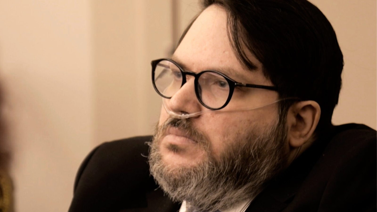 Nicholas Rossi wearing glasses and a nasal cannula during a legal proceeding