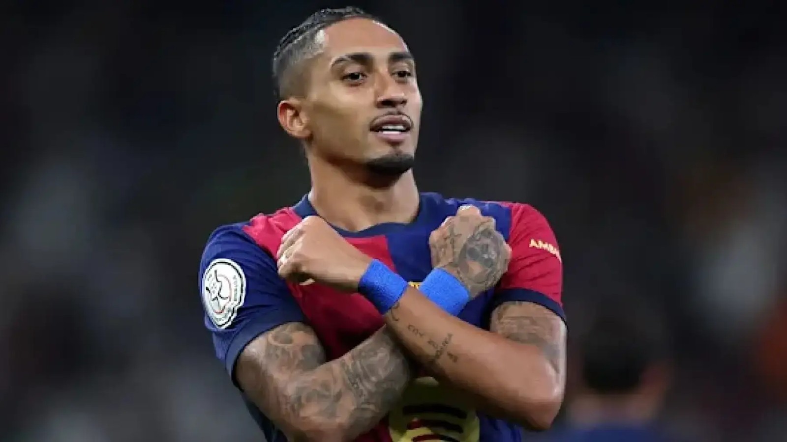 Brazilian footballer Raphinha crossing his arms while wearing the Barcelona team jersey