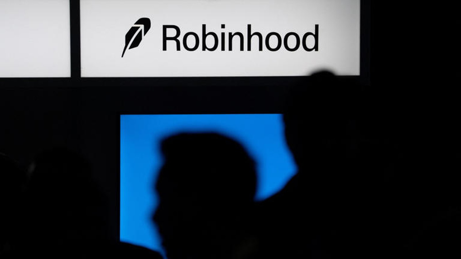 The Robinhood company logo displayed on a bright sign above a dark room