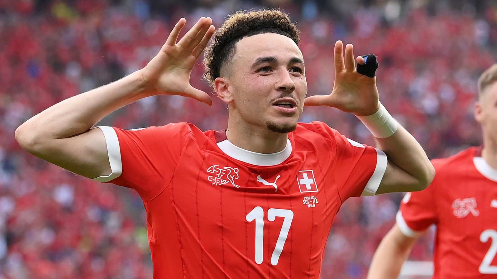 Swiss midfielder Ruben Vargas celebrating a goal while wearing the national team jersey