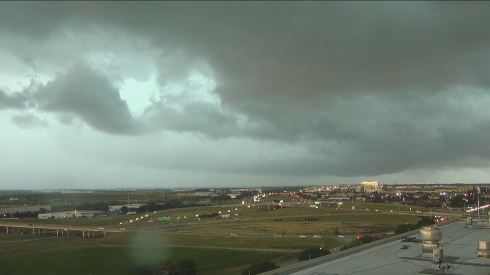 Dark ominous storm clouds looming over a highway interchange in the Dallas area