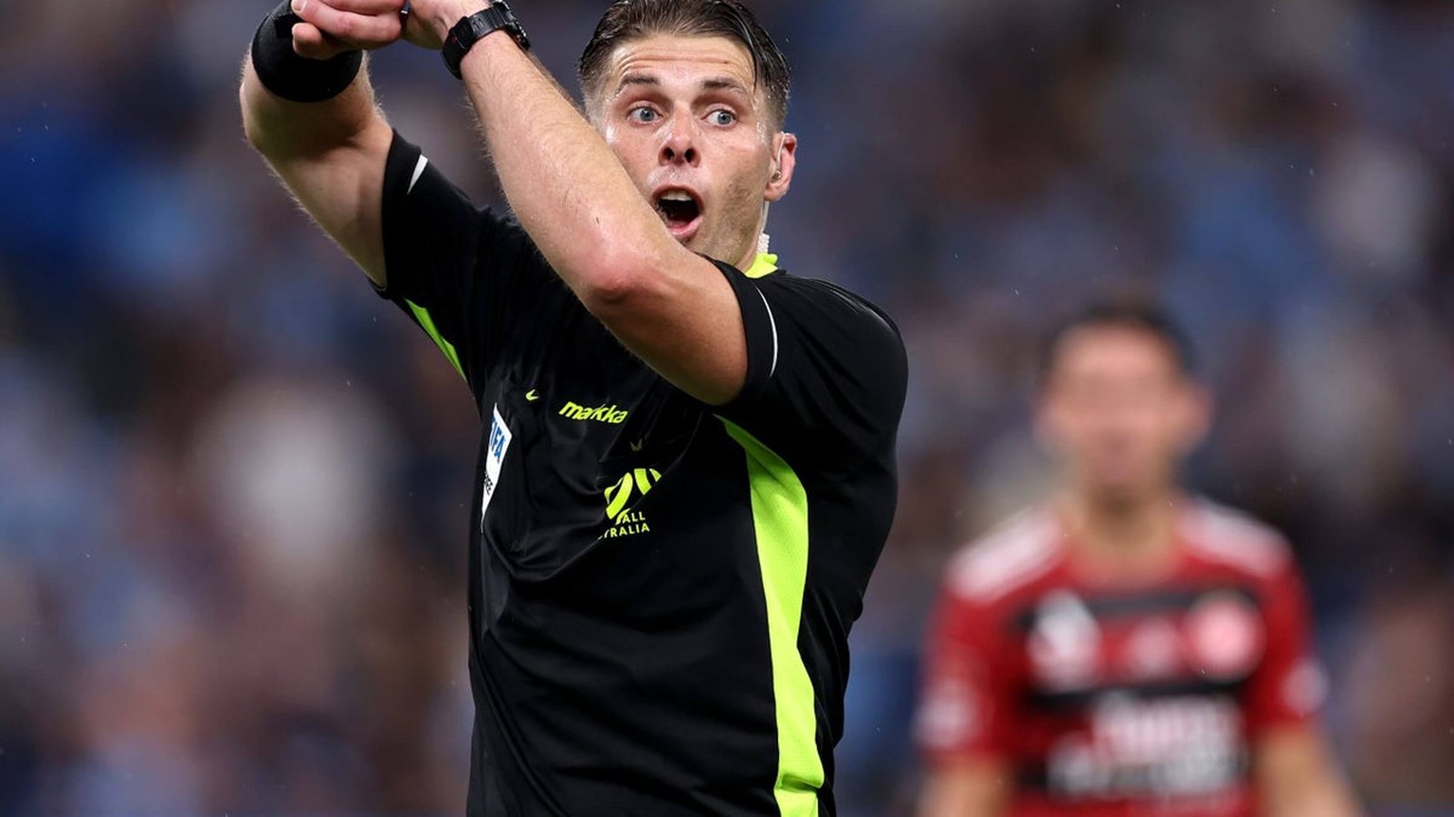 Australian football referee Shaun Evans making a VAR signal during a match