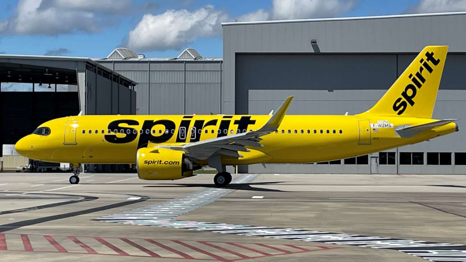 A bright yellow Spirit Airlines passenger jet parked on the airport tarmac