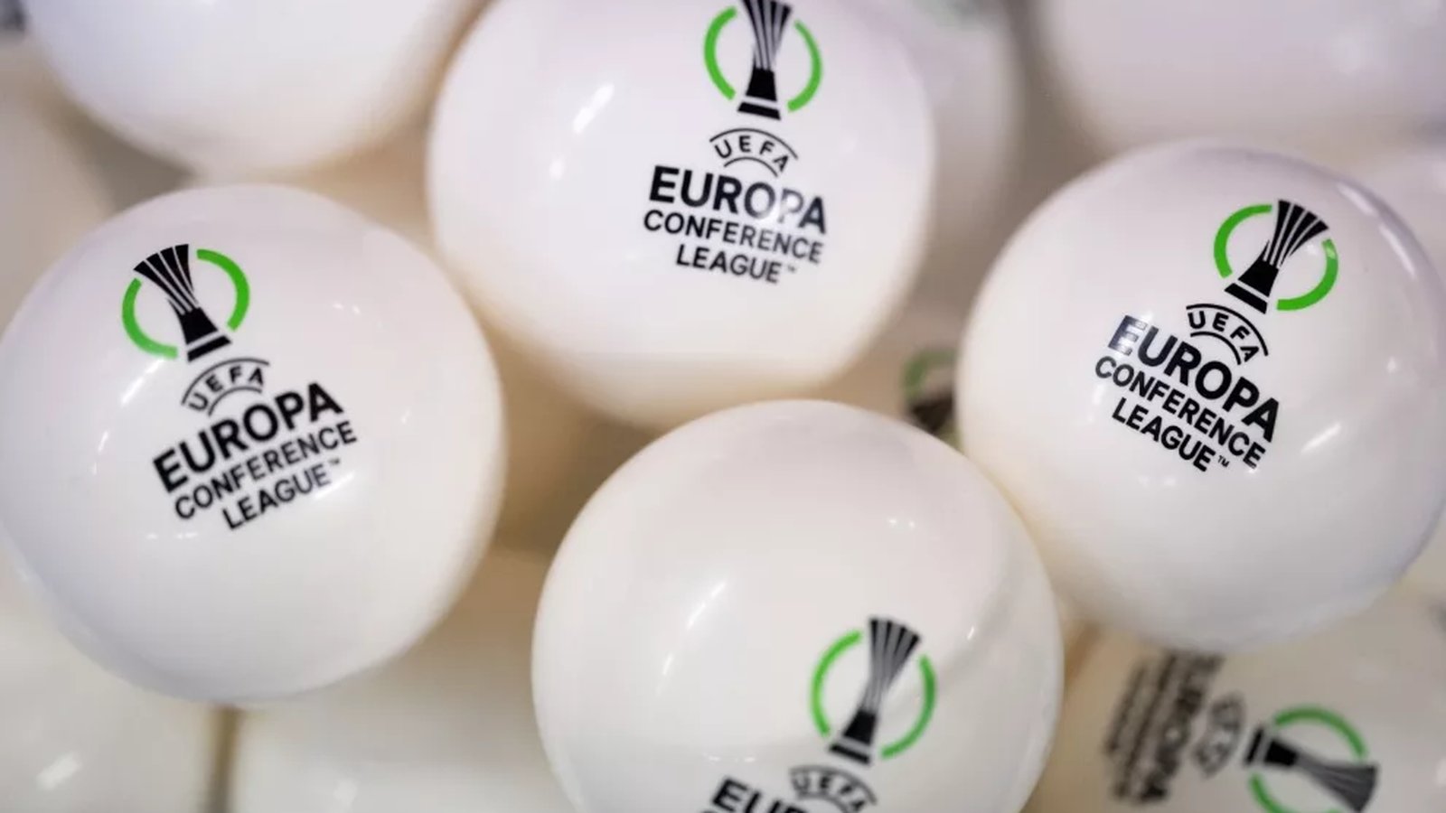 Close up of white ping pong balls with the UEFA Conference League logo printed on them