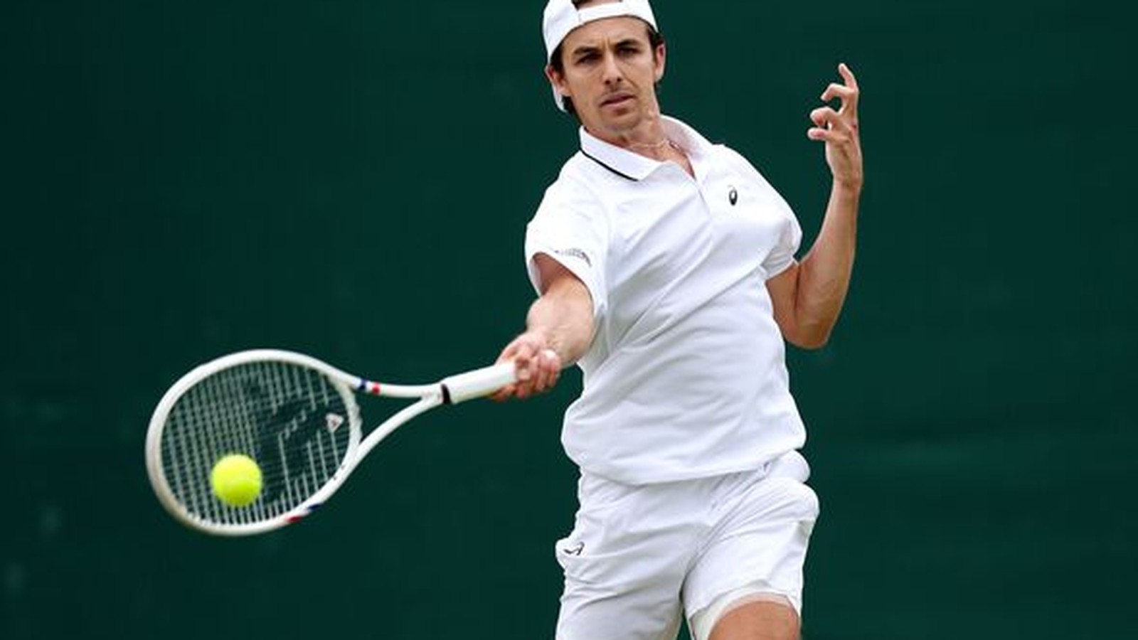 Alex de Minaur hitting a powerful forehand shot during a Wimbledon tennis match