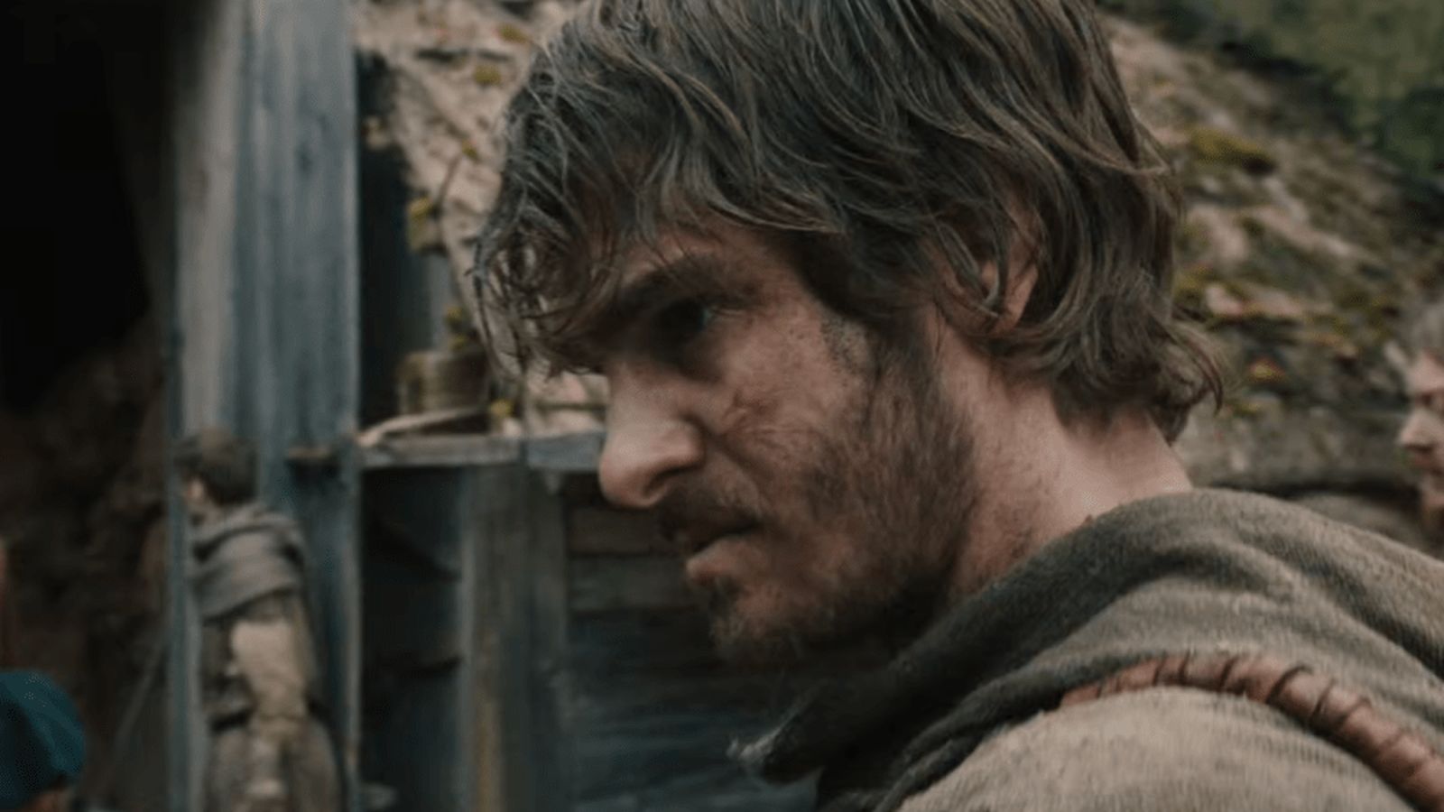 Andrew Garfield with a beard and disheveled hair portraying a peasant in The Uprising