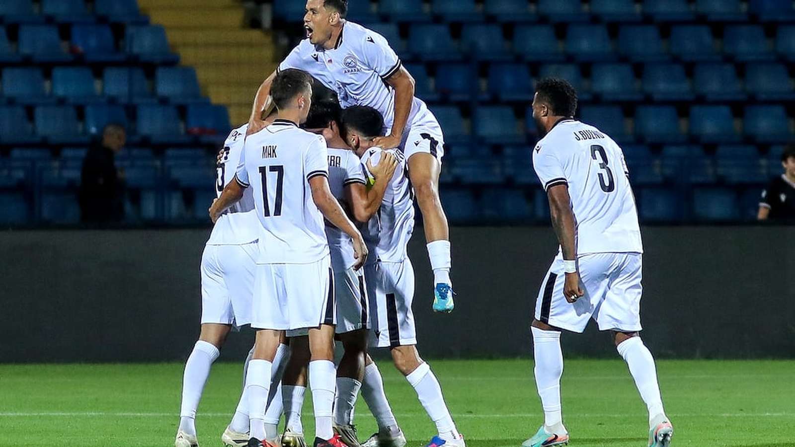 Ararat-Armenia football players in white kits celebrating a goal on the pitch