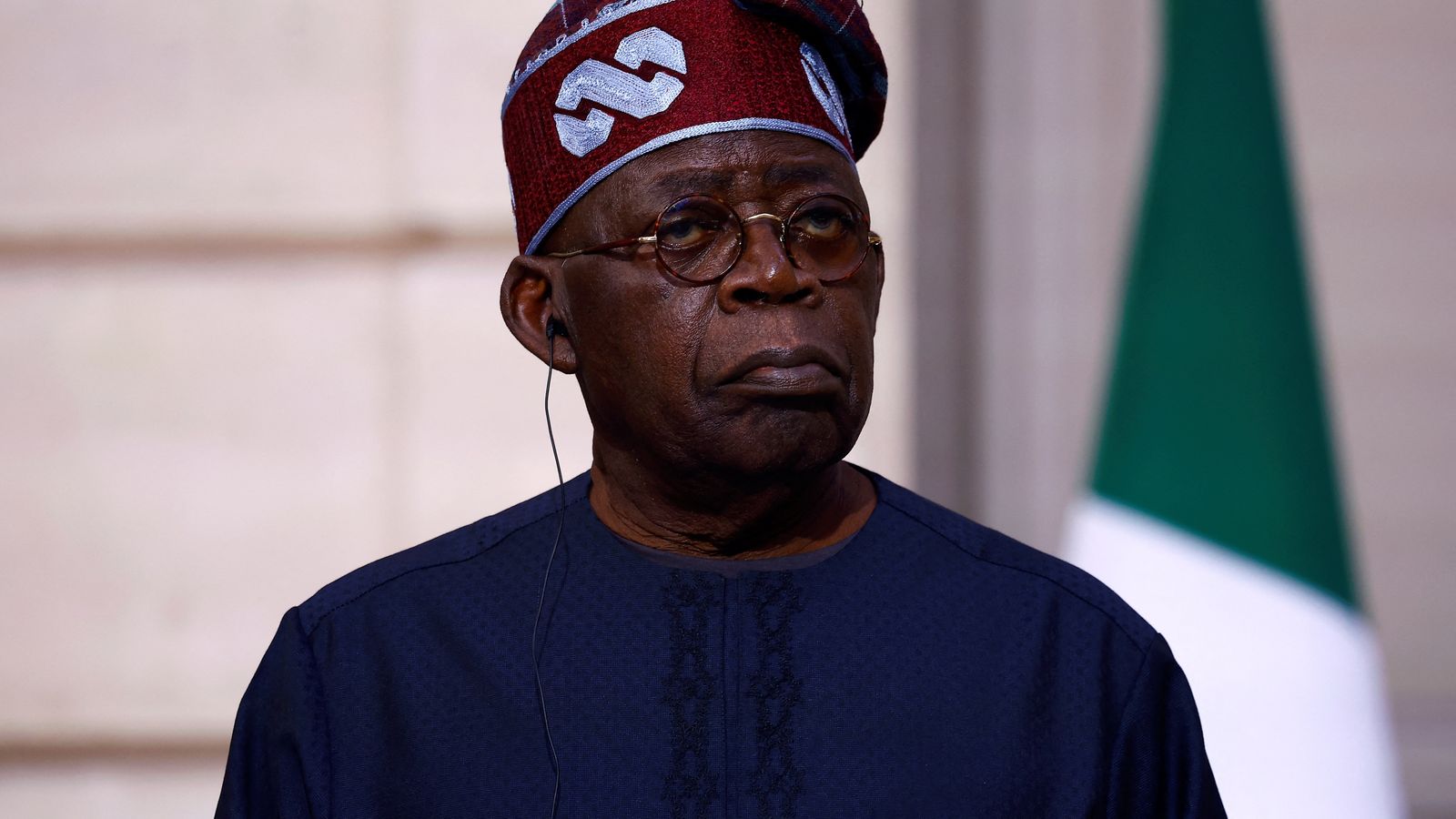 President Bola Tinubu wearing a traditional cap and dark blue attire looking forward