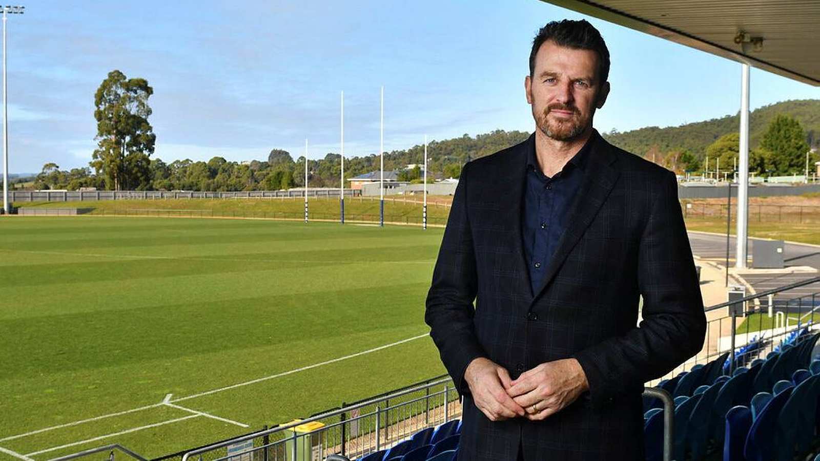 Tasmania Devils CEO Brendon Gale standing in a stadium overlooking the football field