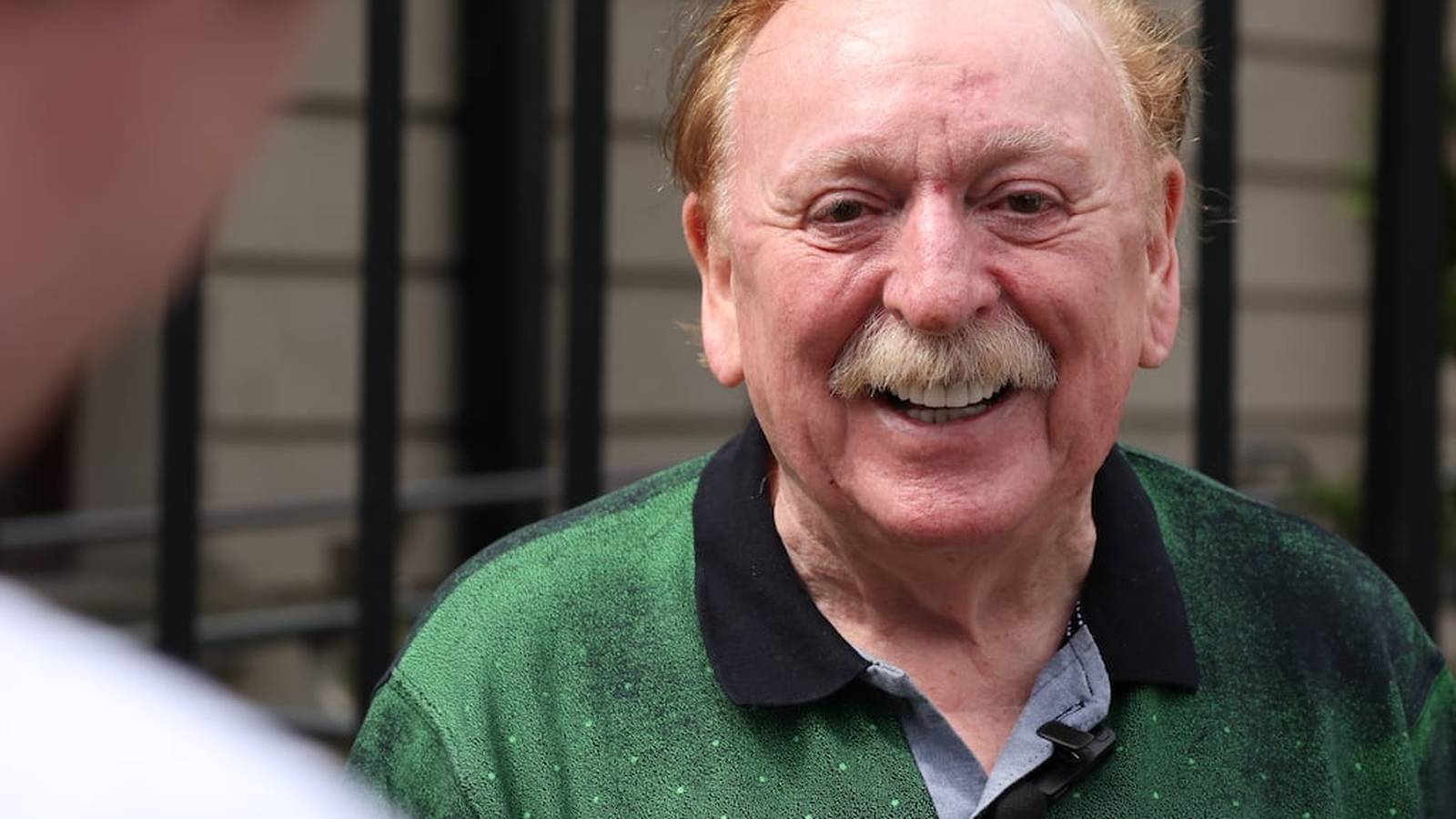 Brian Warfield, singer of The Wolfe Tones, smiling during an interview outdoors