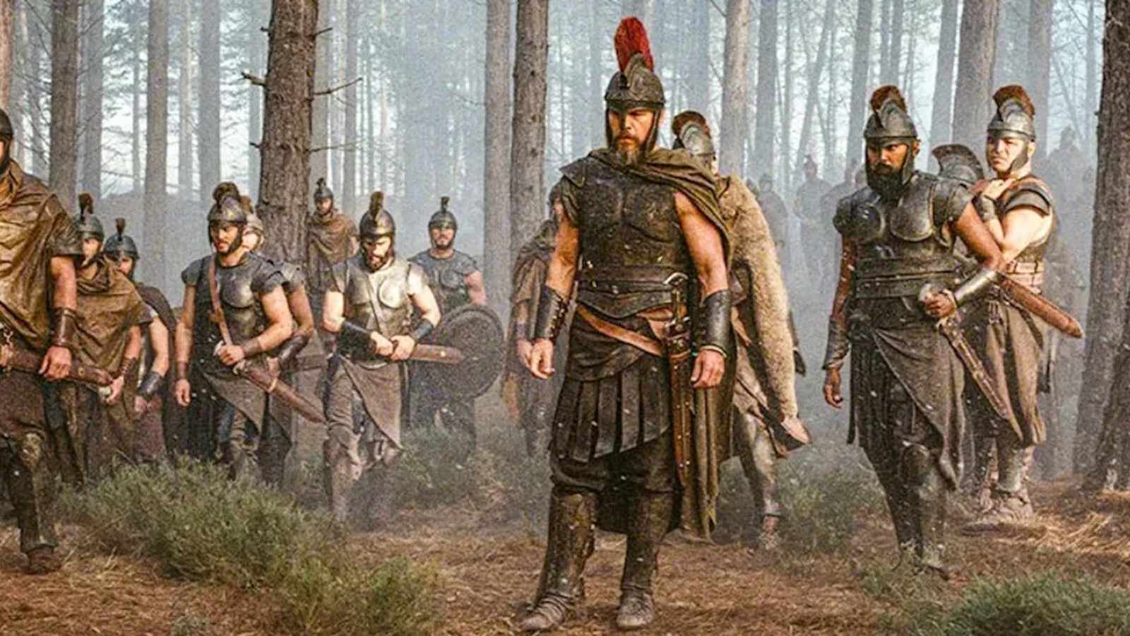 A group of ancient Greek warriors in armor walking through a misty forest