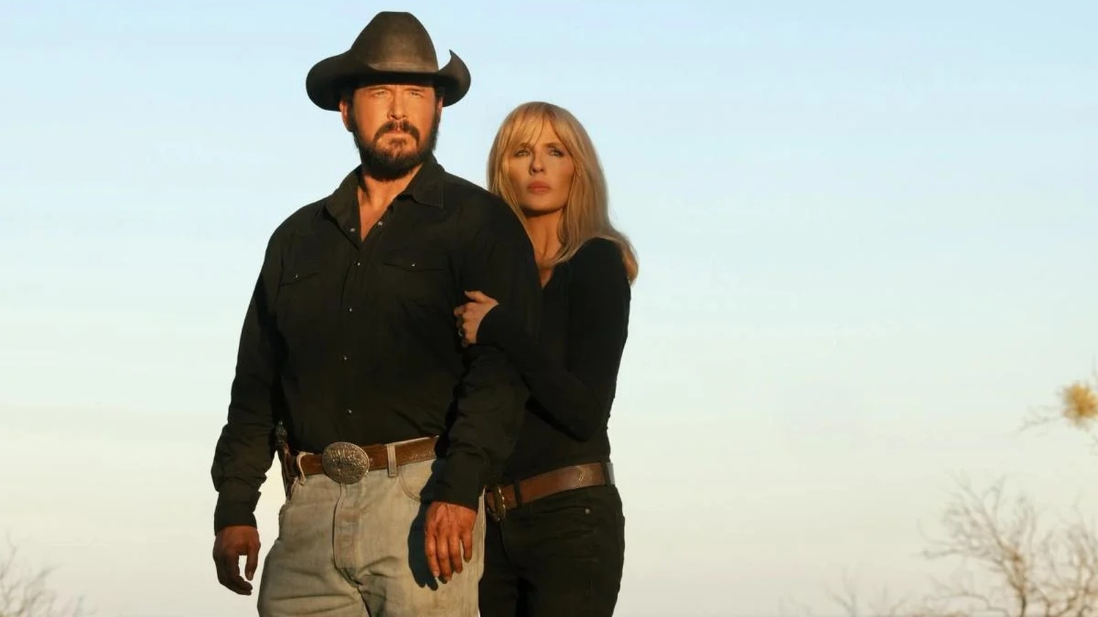 Cole Hauser as John Dutton III and Kelly Reilly as Beth Dutton stand together outdoors