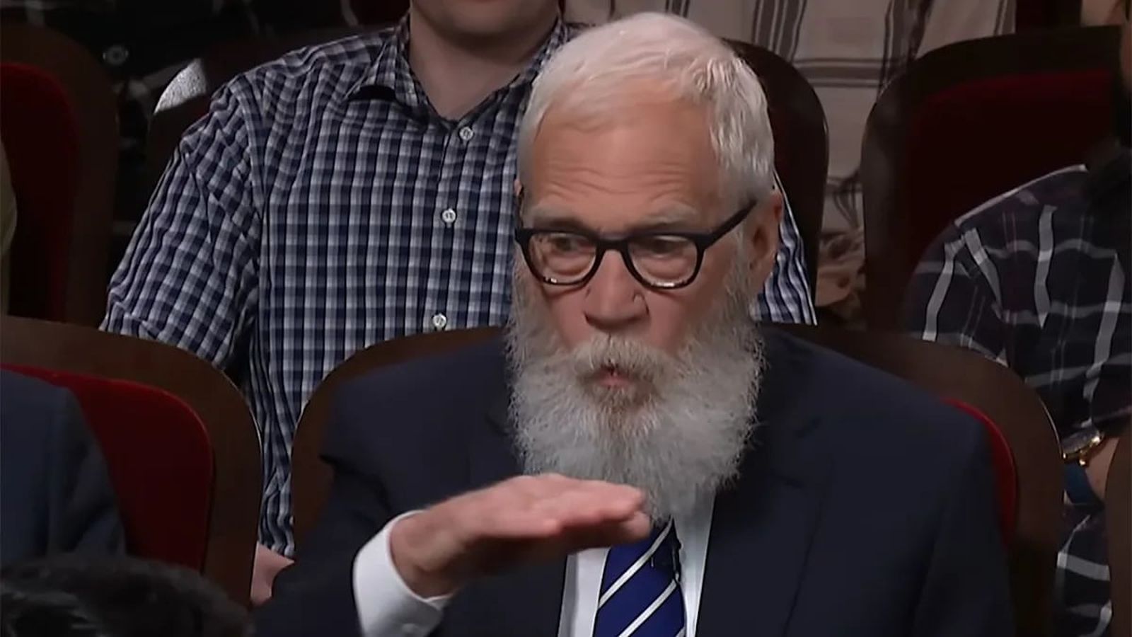 David Letterman with a white beard wearing glasses and a suit during an interview