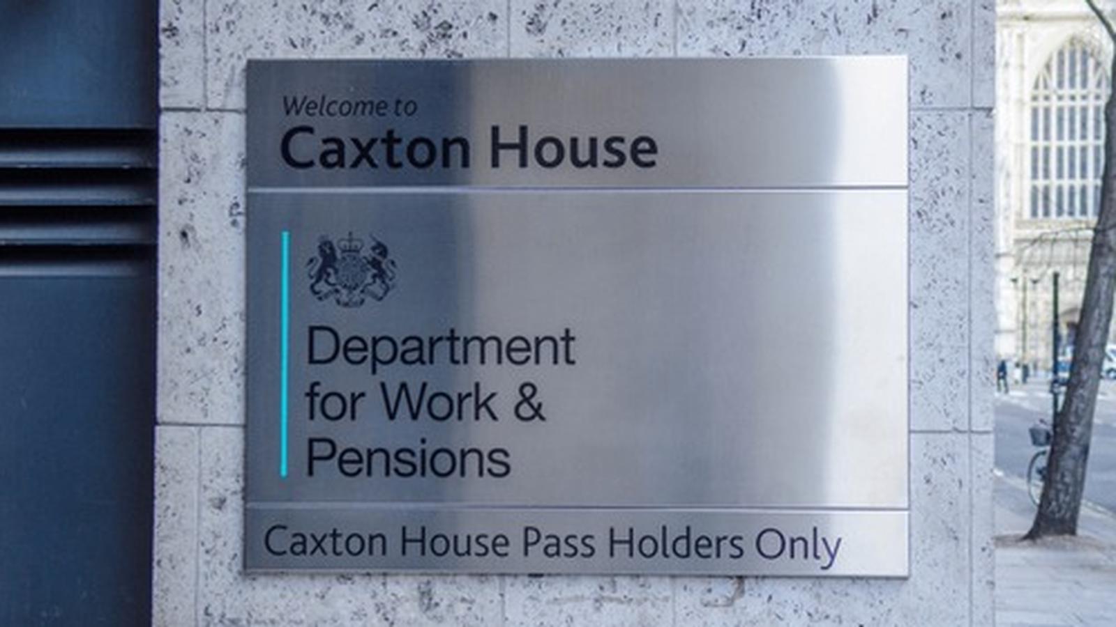 Metal sign for Caxton House Department for Work and Pensions on a stone wall
