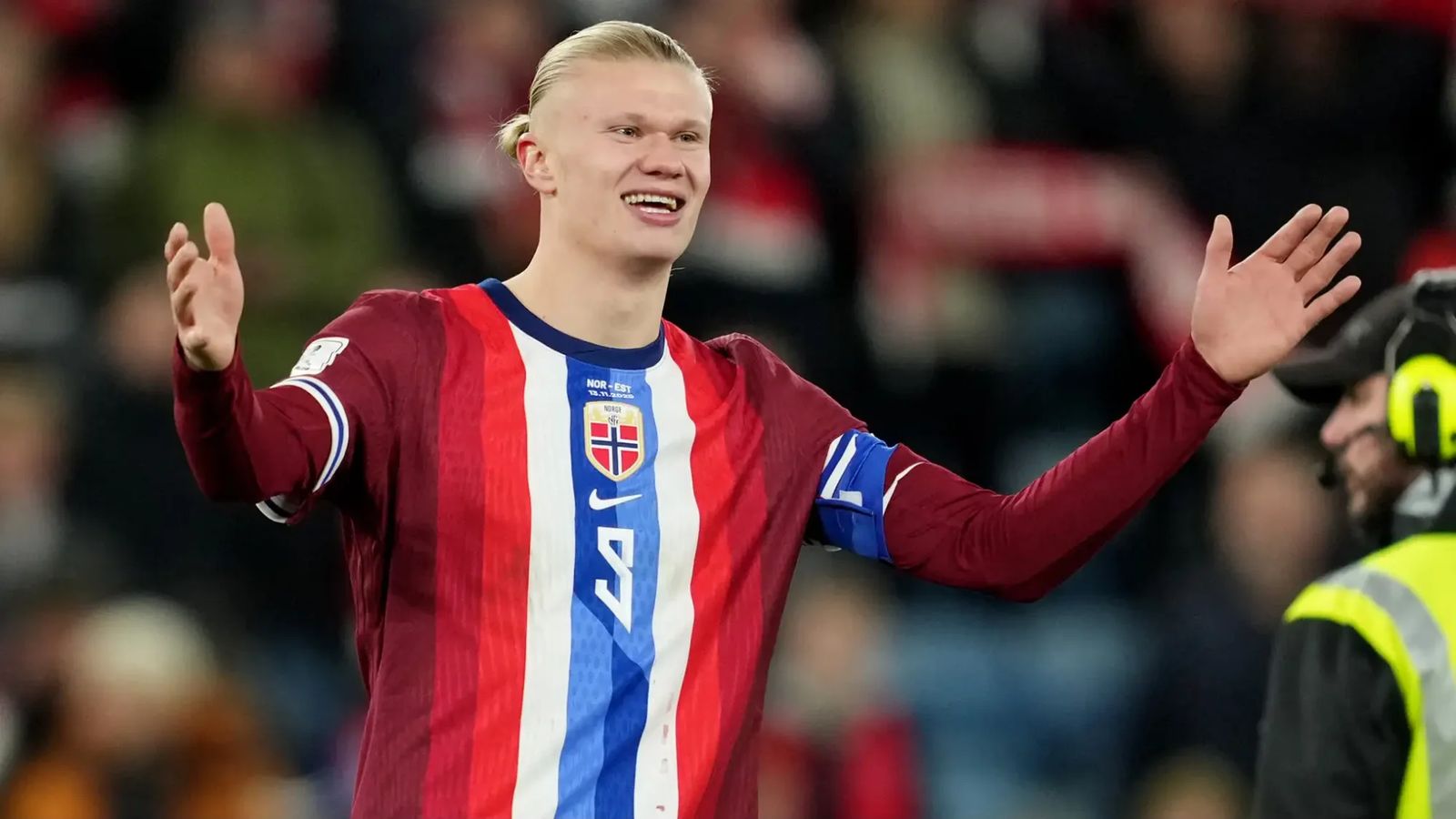 Erling Haaland smiling and gesturing while wearing the Norway national football team jersey
