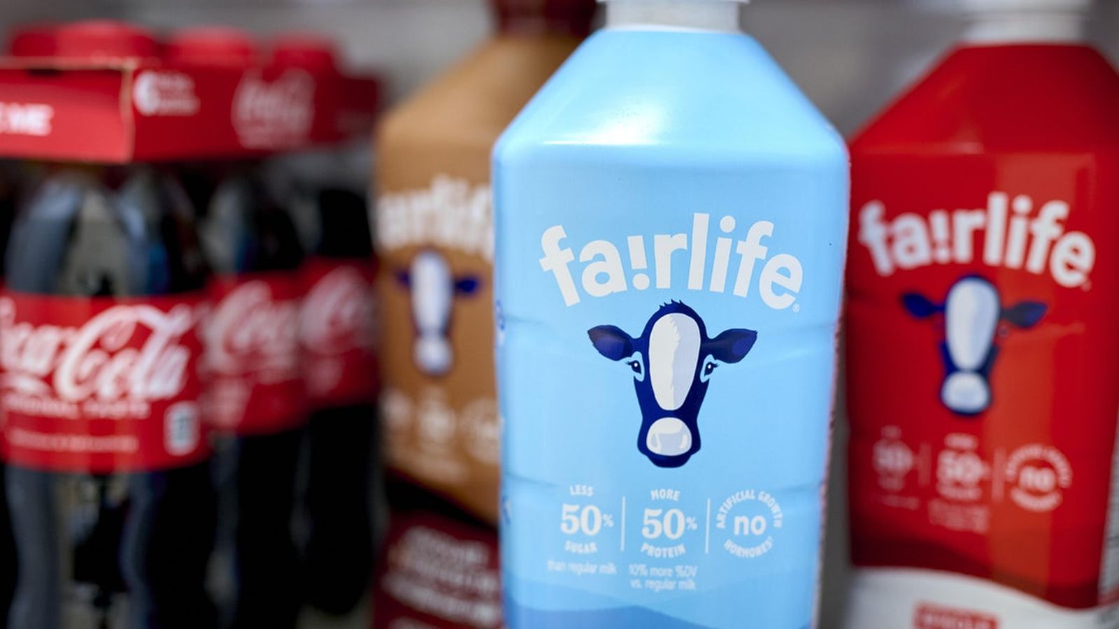 Close up of a light blue Fairlife milk bottle with other products blurred behind