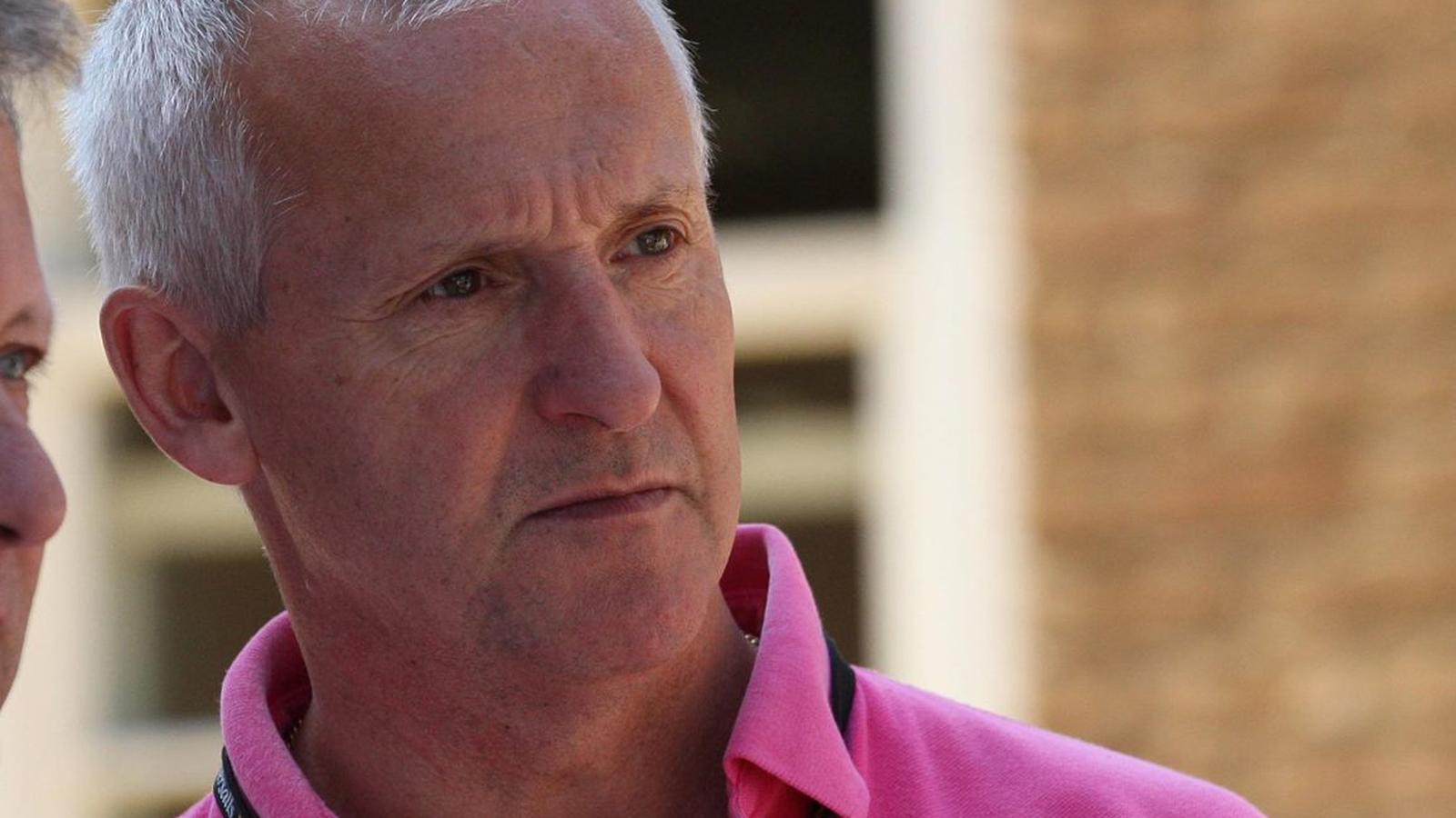 Close up portrait of jockey Graham Bradley wearing a pink polo shirt