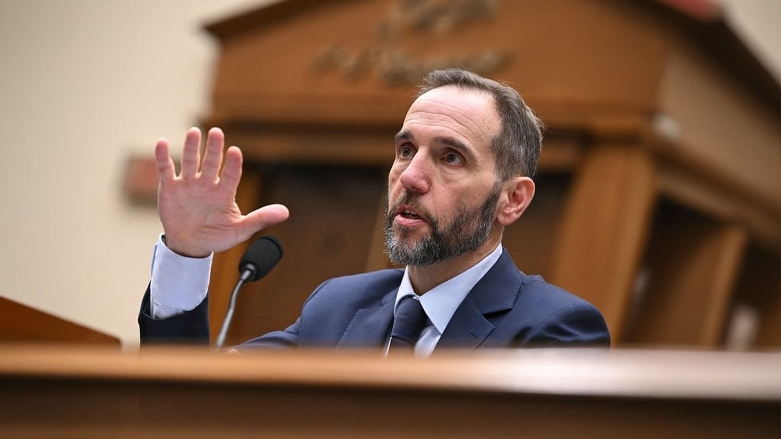 Former special counsel Jack Smith gesturing while speaking at a formal government hearing