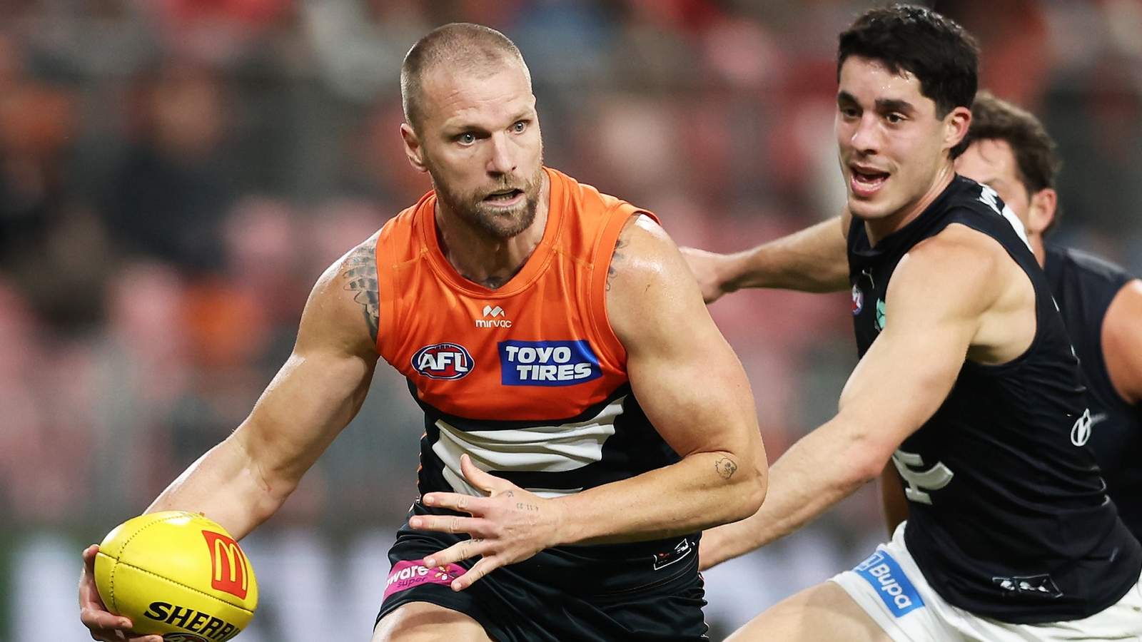 Jake Stringer in a GWS Giants jersey running with the football during an AFL game