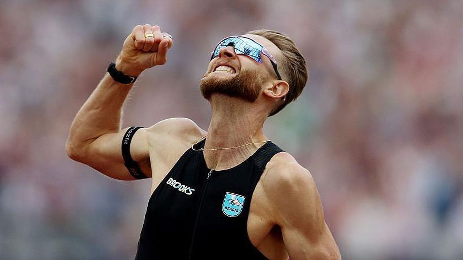 Josh Kerr celebrating his mile world record victory wearing a black Brooks kit
