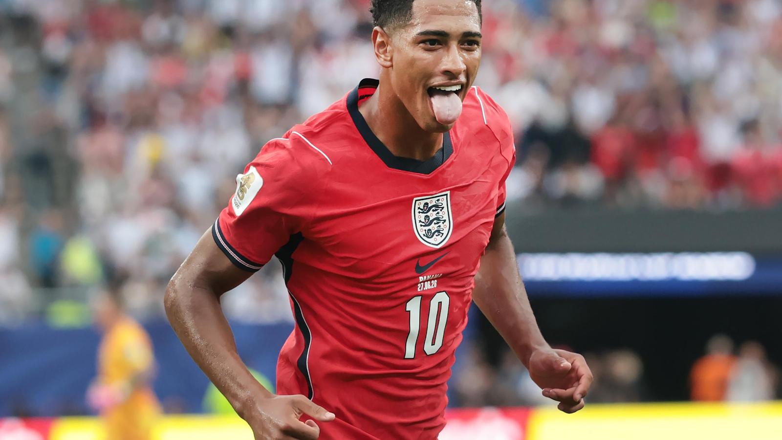 Jude Bellingham celebrating a goal while wearing the red England national team jersey