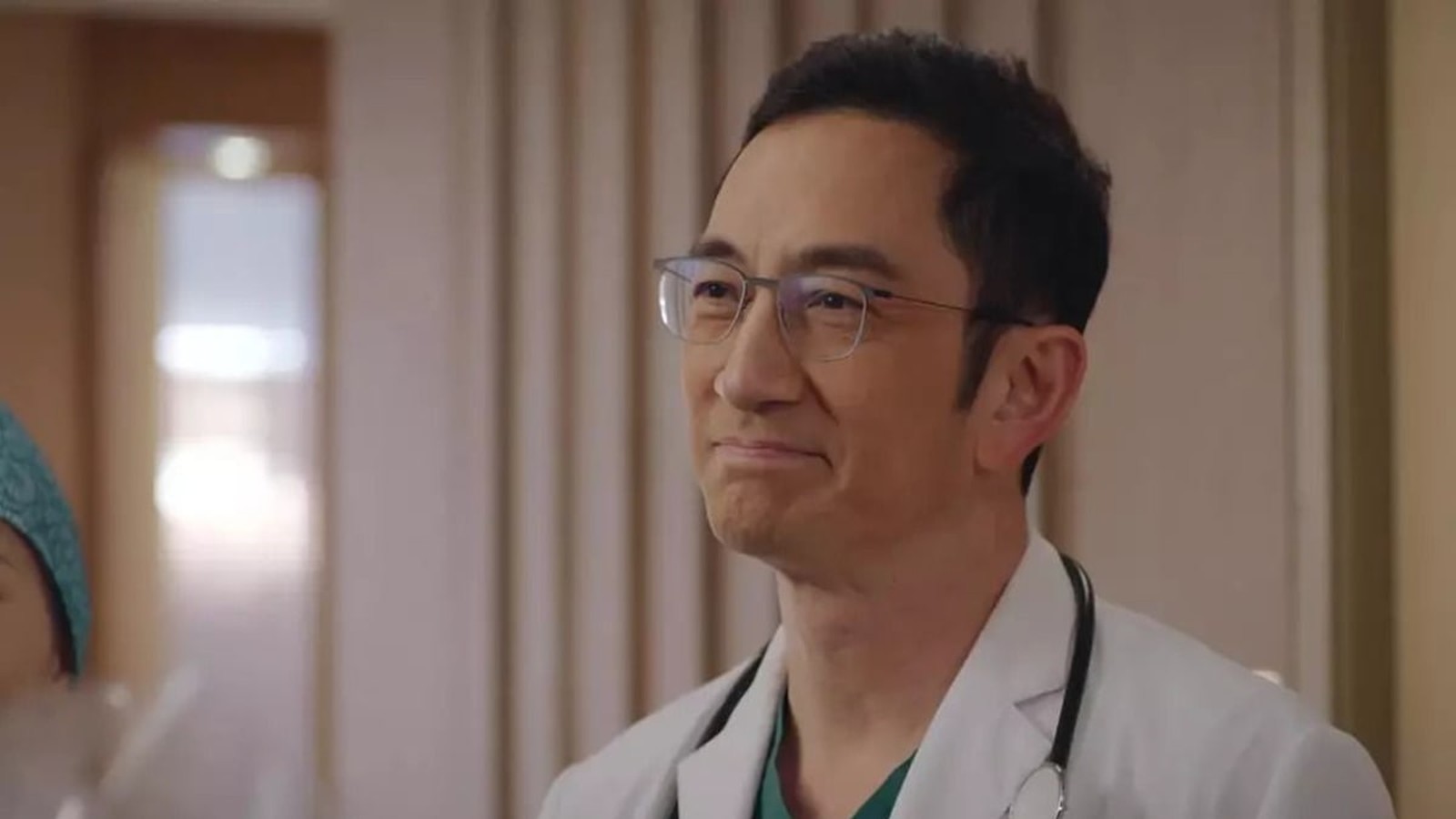 Hong Kong actor Lawrence Ng wearing glasses and a white medical coat smiling