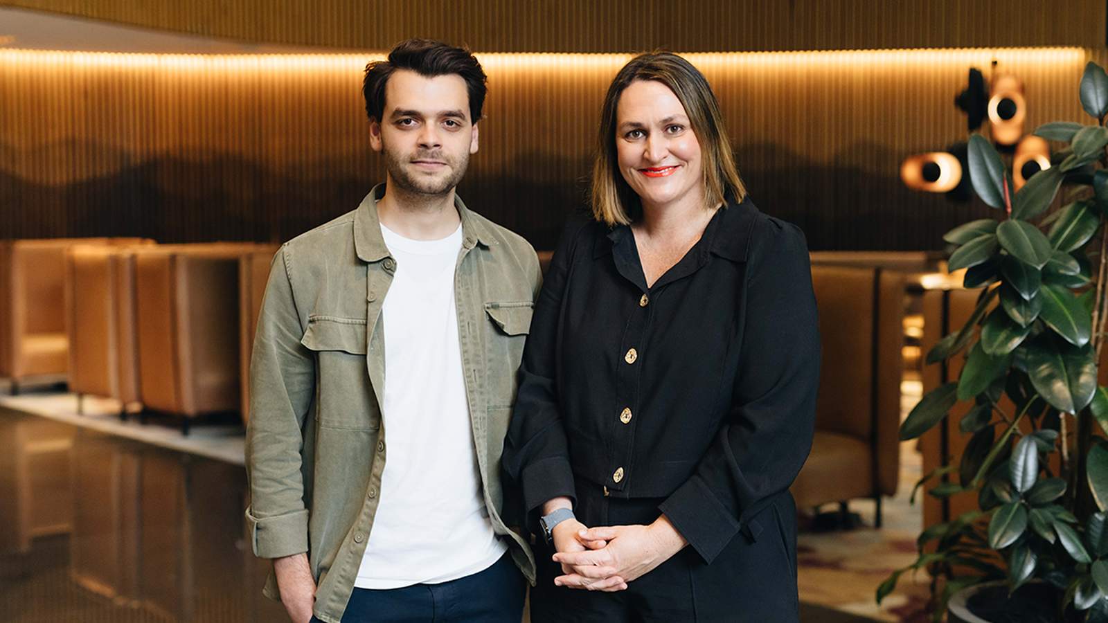 Luca Lavigne standing next to a colleague in a modern office lobby setting
