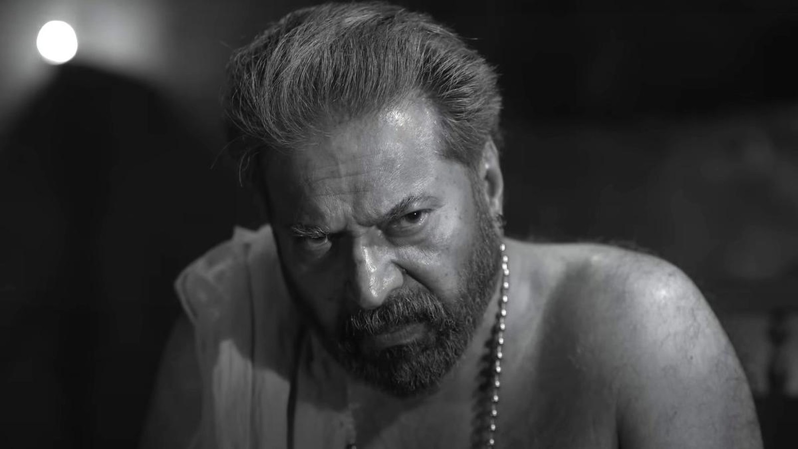 Actor Mammootty looking intense in a black and white film still portrait