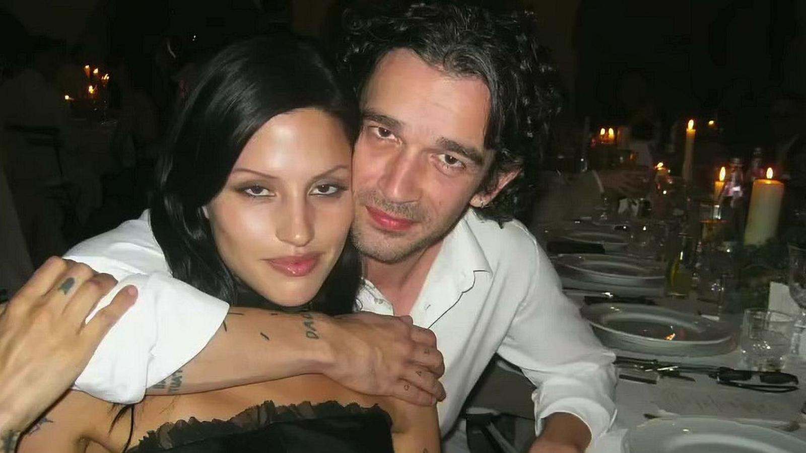 Matty Healy and Gabbriette Bechtel posing together at a candlelit dinner event