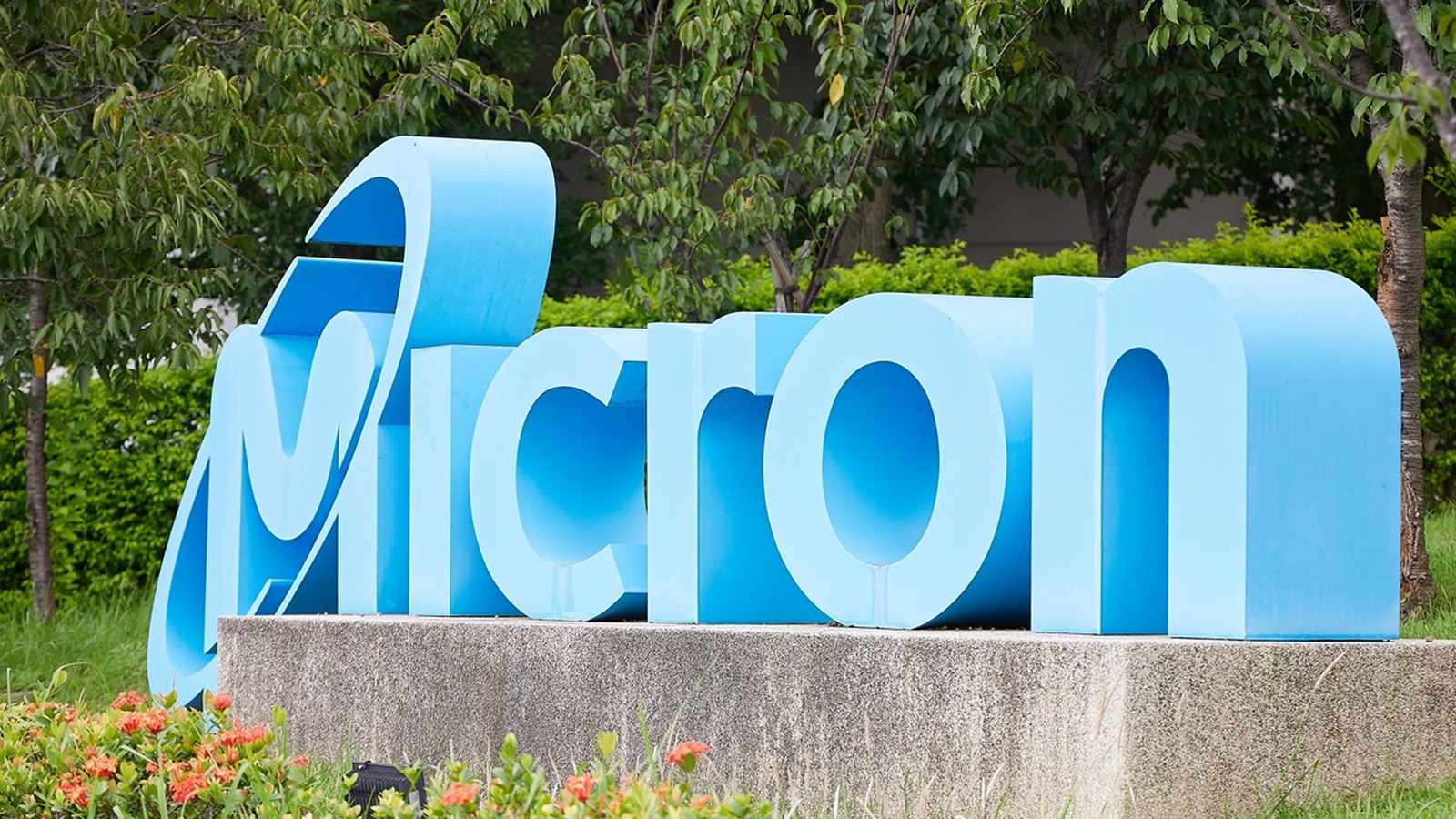 Large blue Micron company logo sign situated in a landscaped garden area outdoors