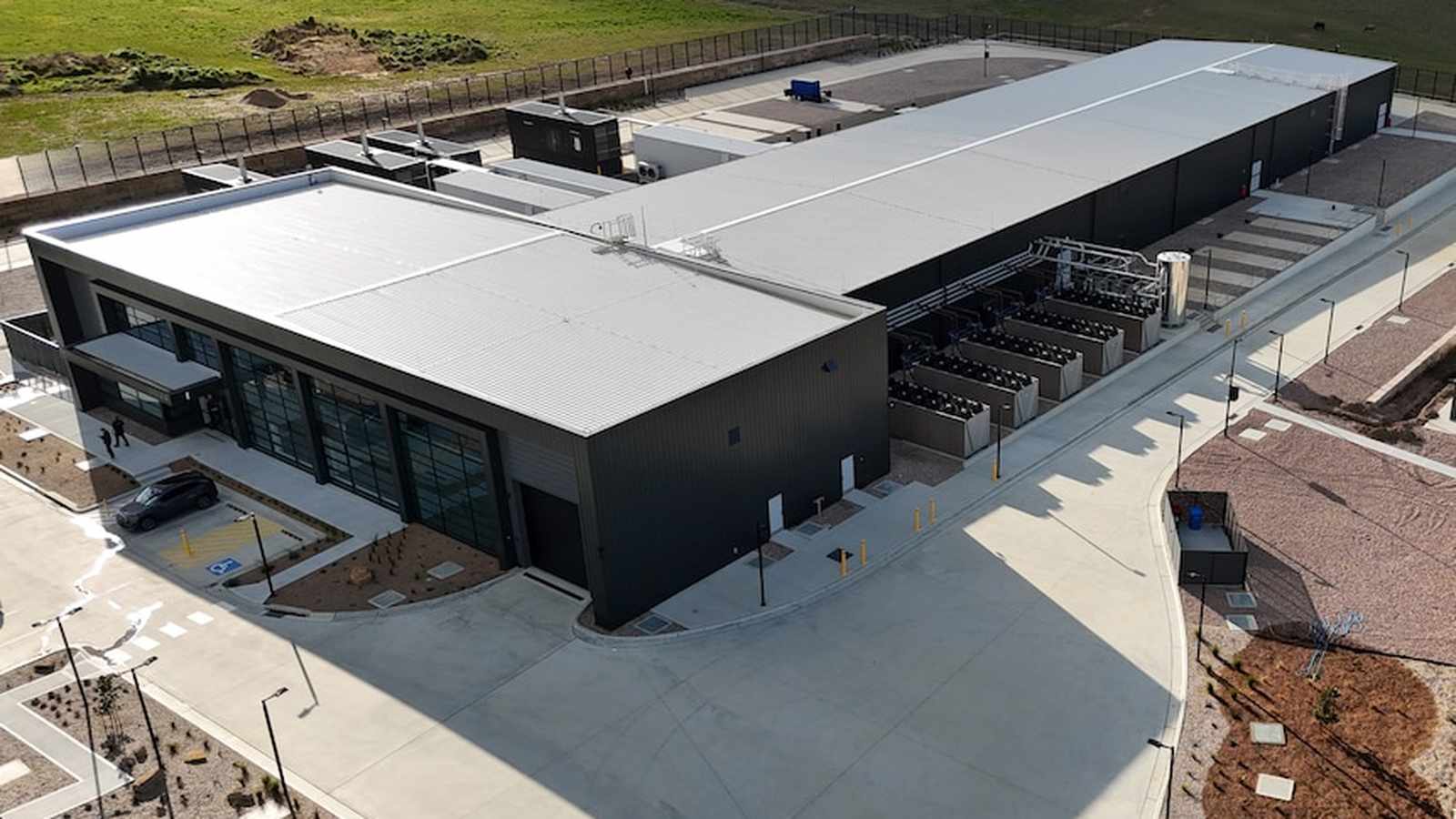 Aerial view of a modern industrial data centre building with cooling units outside