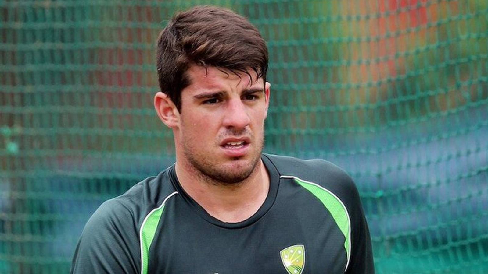 Moises Henriques wearing a dark green cricket training shirt with a logo