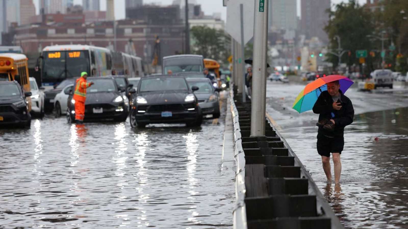 A person with a colorful umbrella walks through flooded streets in New York City