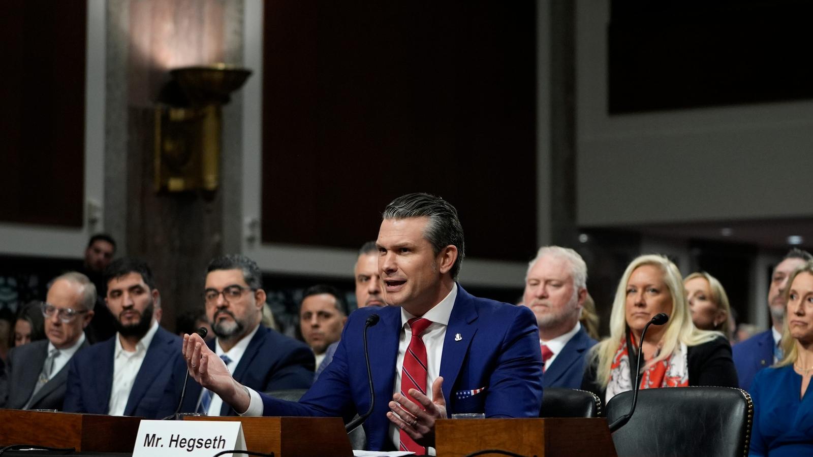 Pete Hegseth speaking at a Senate hearing with a nameplate in front of him