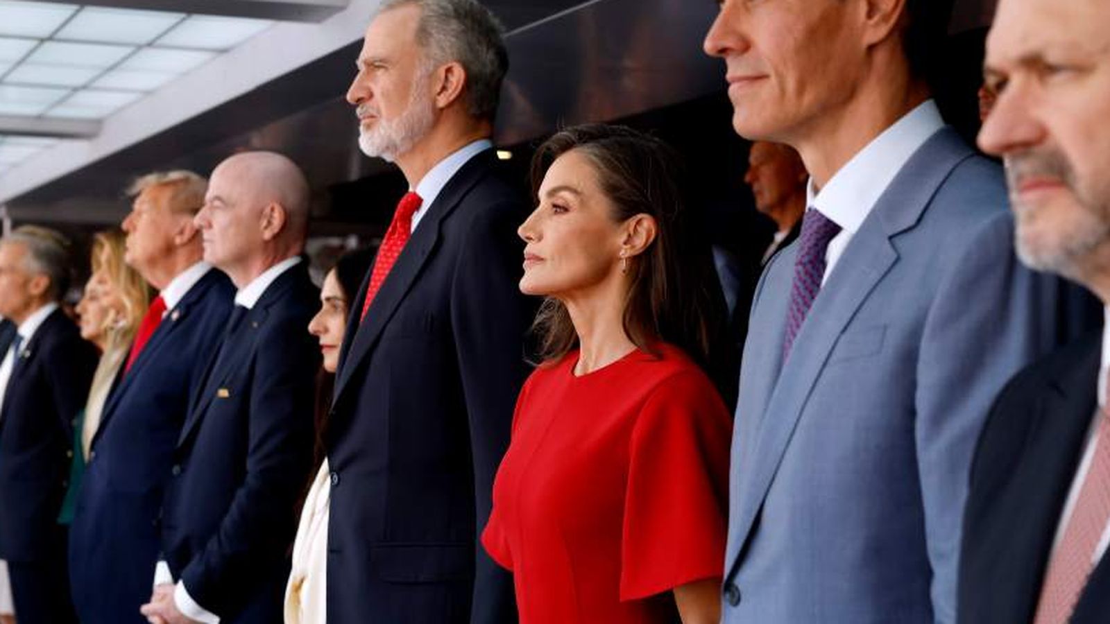 Queen Letizia and King Felipe VI standing in a formal line at stadium